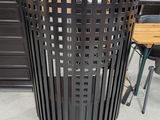 a black trash can in the middle of a room