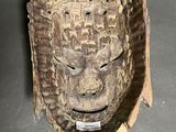 an image of a wooden mask hanging on the wall of a room