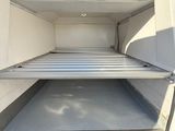 l'arrière d'une camionnette dont la porte est ouverte, laissant entrevoir l'intérieur
