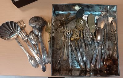 une boîte contenant tout un tas de cuillères en argent et d'autres cuillères
