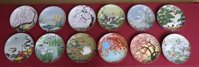 neuf assiettes ornées de motifs variés, posées sur un fond rouge