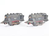 two toy trains sitting side by side on a white surface