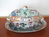 a bowl with a lid on a plate on a table