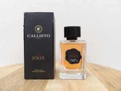 une photo d'un flacon de parfum posé sur une table en bois