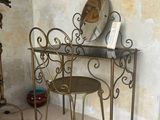 une table avec un miroir et une chaise dans une pièce