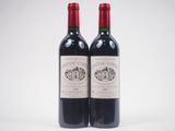 deux bouteilles de vin rouge posées l'une à côté de l'autre sur une surface blanche