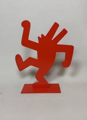 a red sculpture of a man on a skateboard on a white surface