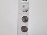 quatre types de pièces différents sont présentés sur une surface blanche