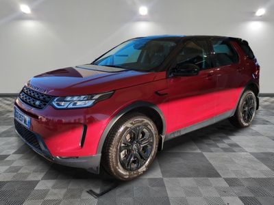 a red land rover parked in a garage with a checkered floor