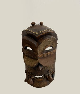 a close up of a wooden mask on a white background