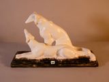 une statue représentant un chien et un chat allongés sur une table