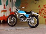 a motorcycle parked in front of a wall with graffiti on it