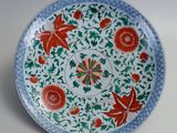an image of a decorative plate with flowers and leaves on it