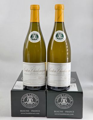 two bottles of white wine sitting on top of a black box