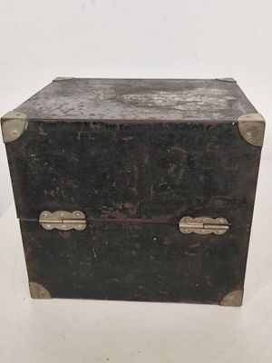 une petite boîte noire posée sur une table blanche