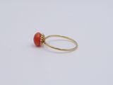 a gold ring with a red stone on it