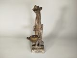 une statue représentant une girafe sur laquelle est posé un bol