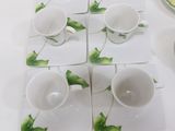 several cups and saucers are sitting on a table with plates and bowls