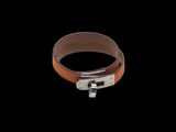 brown leather bracelet with a silver clasp on a black background