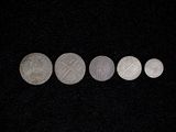 five silver coins are arranged in a row on a black background