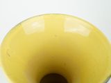 a yellow vase that is sitting on a table