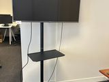 un téléviseur à écran plat posé sur un meuble dans un bureau