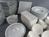 a lot of white plates and bowls on the table
