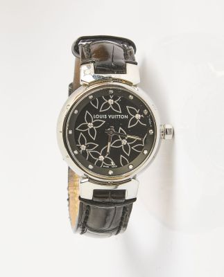 un gros plan d'une montre sur une surface blanche avec un fond blanc