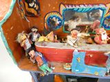 une petite maison de poupées avec plein de figurines à l'intérieur