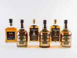 four bottles of whiskey lined up in a row on a white surface