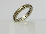 a gold ring with black dots on it sitting on a white surface