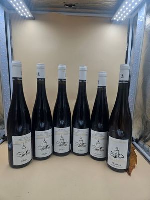 six bouteilles de vin sont alignées sur un comptoir