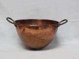 une vieille casserole en cuivre avec des anses, sur fond blanc
