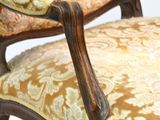 a close up of a chair with a yellow and gold upholstered upholstered seat