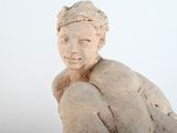 a small statue of a man sitting on a rock