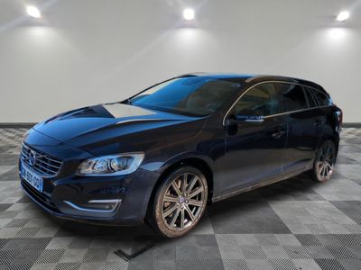 une Volvo break bleue garée dans une pièce au sol carrelé