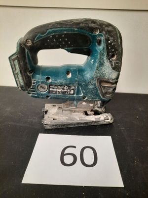 un gros plan d'une scie sauteuse filaire posée sur une table