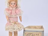 a small doll that is standing next to a box