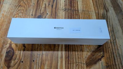 une boîte d'Apple Watch posée sur un parquet, à côté d'un parquet