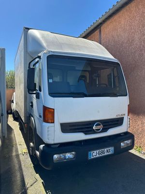 un camion blanc garé à côté d'un immeuble