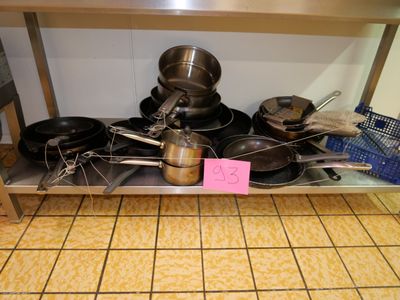 de nombreuses casseroles et poêles sur l'étagère de la cuisine