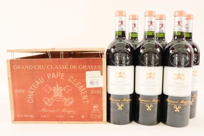 six bouteilles de vin rouge dans un coffret en bois posé sur une surface blanche