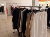 un portemanteau dans un magasin de vêtements, sur lequel sont suspendus des vêtements