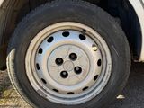 a white truck with a flat tire parked on the side of the road