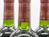 three bottles of wine are lined up on a table