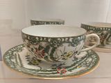 two cups and saucers on display in a glass case
