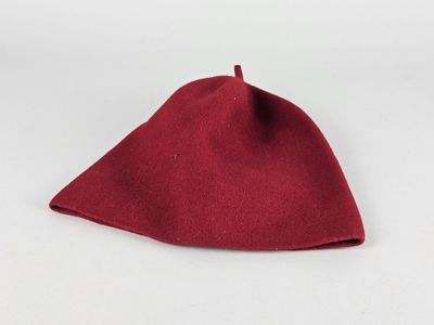 un gros plan d'un chapeau rouge posé sur une surface blanche