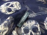 blue and white skull print fabric with a tag on it