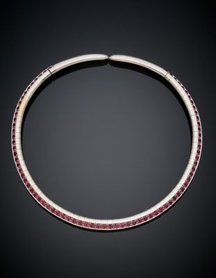 a silver necklace with pink stones on a black background