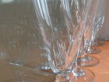 plusieurs verres à vin vides alignés sur une table devant une fenêtre